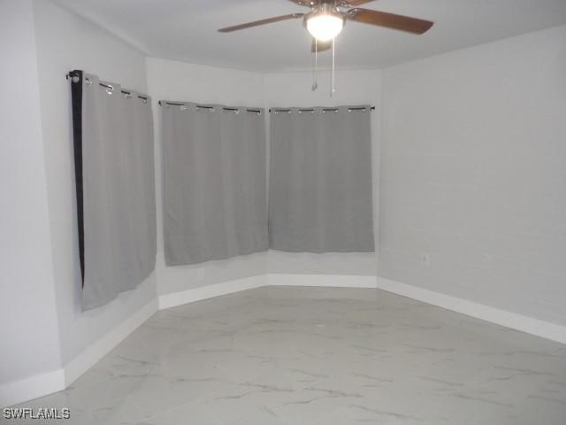 3805 6th St W, Lehigh Acres, FL 33971 - spare room featuring ceiling fan, baseboards, and marble finish flooring