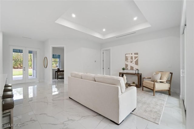 living area featuring light marble finish floors, french doors, recessed lighting, a tray ceiling, and baseboards