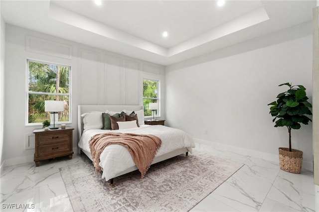 bedroom with a raised ceiling, light marble finish flooring, baseboards, and recessed lighting