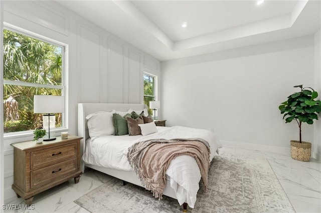 bedroom with light marble finish flooring, a raised ceiling, and recessed lighting