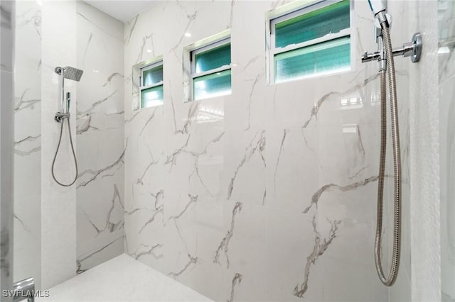 bathroom featuring a marble finish shower