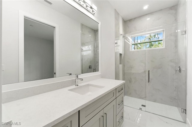 full bath featuring a marble finish shower, vanity, and marble finish floors