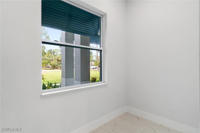 unfurnished room featuring baseboards, plenty of natural light, and marble finish flooring