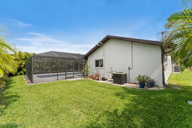 2124 SE 10th Ln, Cape Coral, FL 33990 - rear view of property featuring cooling unit, stucco siding, a lawn, and an outdoor pool
