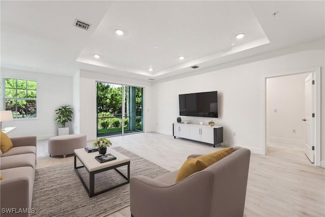 26380 Coco Cay Cir Unit 101, Bonita Springs, FL 34135 - living area featuring a raised ceiling, plenty of natural light, recessed lighting, light wood-style flooring, and baseboards