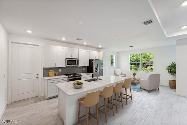 26380 Coco Cay Cir Unit 101, Bonita Springs, FL 34135 - kitchen with appliances with stainless steel finishes, a sink, an island with sink, a kitchen bar, and recessed lighting