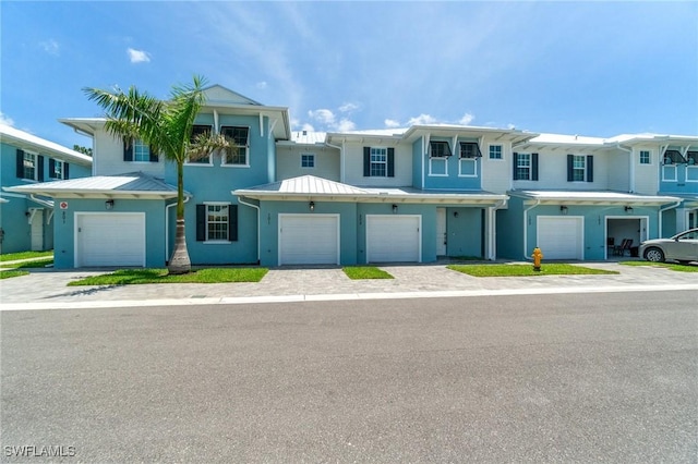 26380 Coco Cay Cir Unit 101, Bonita Springs, FL 34135 - view of property with a standing seam roof, stucco siding, a garage, metal roof, and driveway