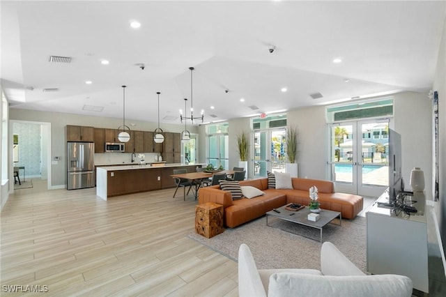 26380 Coco Cay Cir Unit 101, Bonita Springs, FL 34135 - living room featuring recessed lighting, light wood-style flooring, and lofted ceiling