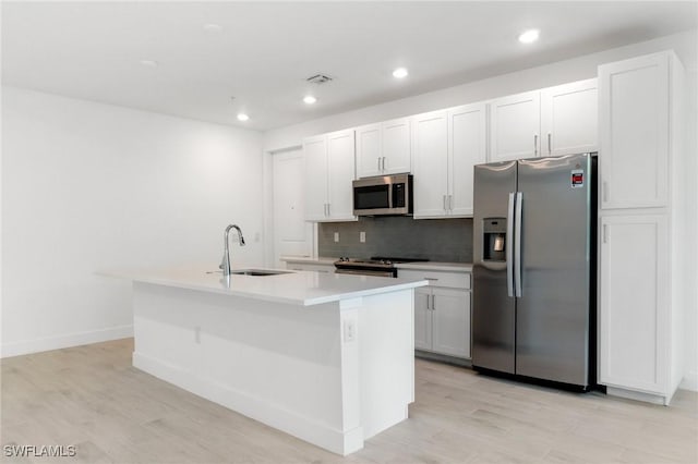 26380 Coco Cay Cir Unit 101, Bonita Springs, FL 34135 - kitchen with stainless steel appliances, a sink, a kitchen island with sink, decorative backsplash, and light wood finished floors