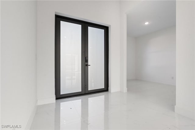 spare room with marble tiled floors, baseboards, recessed lighting, and french doors