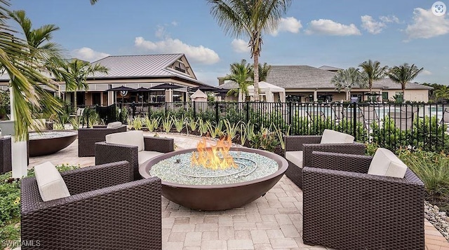 view of patio / terrace featuring fence and an outdoor living space with a fire pit