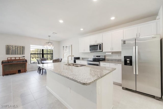 4969 Seton St, Ave Maria, FL 34142 - kitchen featuring appliances with stainless steel finishes, a sink, a chandelier, a kitchen island with sink, and white cabinetry