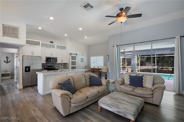 8970 Woodgate Manor Ct, Fort Myers, FL 33908 - living room with a ceiling fan, a barn door, dark wood finished floors, recessed lighting, and high vaulted ceiling