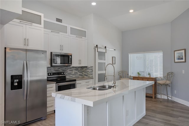 8970 Woodgate Manor Ct, Fort Myers, FL 33908 - kitchen featuring stainless steel appliances, a sink, decorative backsplash, light wood-style flooring, and recessed lighting
