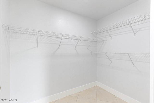 walk in closet with light tile patterned floors