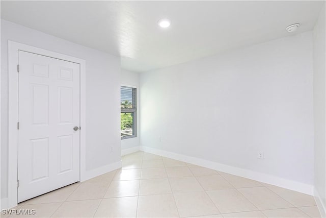 unfurnished room featuring light tile patterned floors, baseboards, recessed lighting, and a smoke detector
