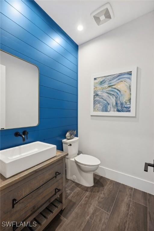 15392 Old Pine Ct, Fort Myers, FL 33912 - bathroom with vanity, toilet, wood finished floors, baseboards, and wood walls