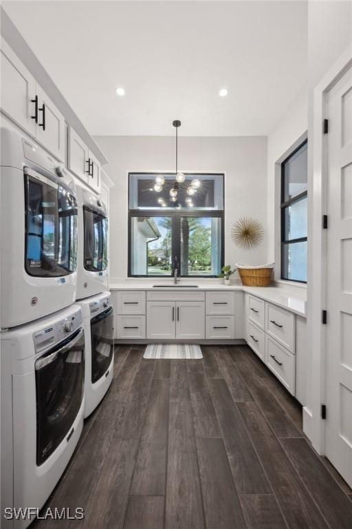 15392 Old Pine Ct, Fort Myers, FL 33912 - washroom featuring cabinet space, stacked washer and clothes dryer, dark wood-style flooring, and recessed lighting