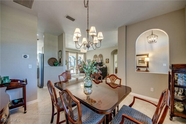 16112 Cutters Ct, Fort Myers, FL 33908 - dining space with a chandelier, arched walkways, baseboards, and light tile patterned floors
