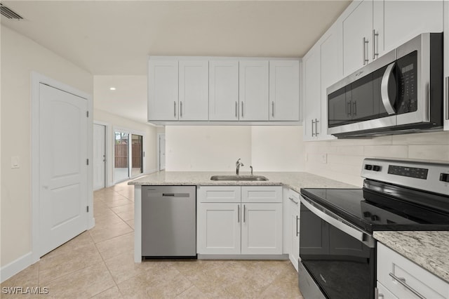 17307 Timber Oak Ln, Fort Myers, FL 33908 - kitchen with stainless steel appliances, a sink, white cabinetry, backsplash, and recessed lighting