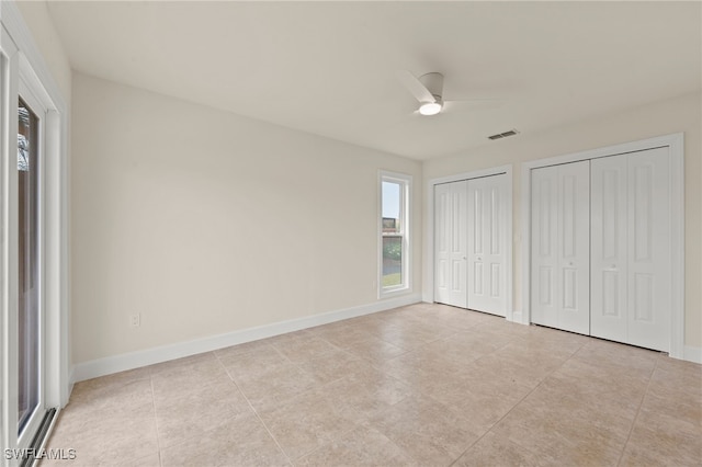 17307 Timber Oak Ln, Fort Myers, FL 33908 - unfurnished bedroom with two closets, light tile patterned flooring, baseboards, and a ceiling fan
