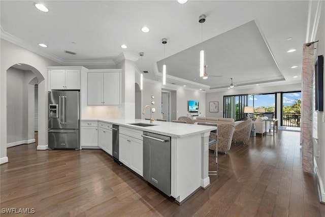 4750 Via Del Corso Ln Unit 201, Bonita Springs, FL 34134 - kitchen featuring stainless steel appliances, a sink, arched walkways, a peninsula, and a raised ceiling