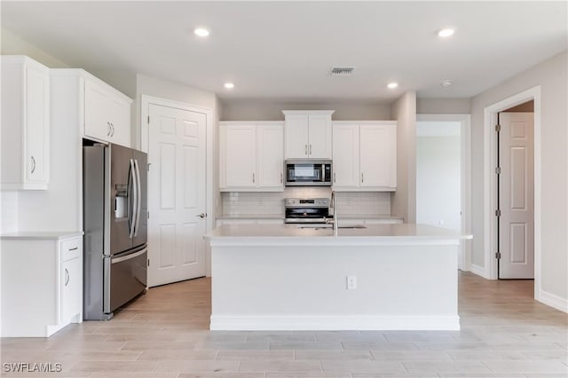 16811 Elkhorn Coral Dr, North Fort Myers, FL 33903 - kitchen with appliances with stainless steel finishes, light countertops, white cabinetry, decorative backsplash, and recessed lighting