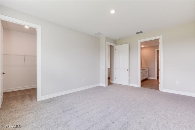 16811 Elkhorn Coral Dr, North Fort Myers, FL 33903 - unfurnished bedroom with carpet, a walk in closet, recessed lighting, and ensuite bathroom