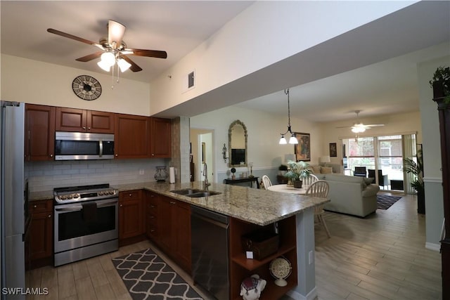 20321 Estero Gardens Cir Unit 108, Estero, FL 33928 - kitchen featuring stainless steel appliances, a sink, a ceiling fan, open floor plan, and a peninsula