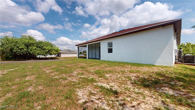2505 4th St SW, Lehigh Acres, FL 33976 - back of property featuring stucco siding, a yard, and cooling unit