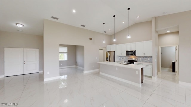 2505 4th St SW, Lehigh Acres, FL 33976 - kitchen featuring appliances with stainless steel finishes, a sink, light countertops, baseboards, and white cabinetry