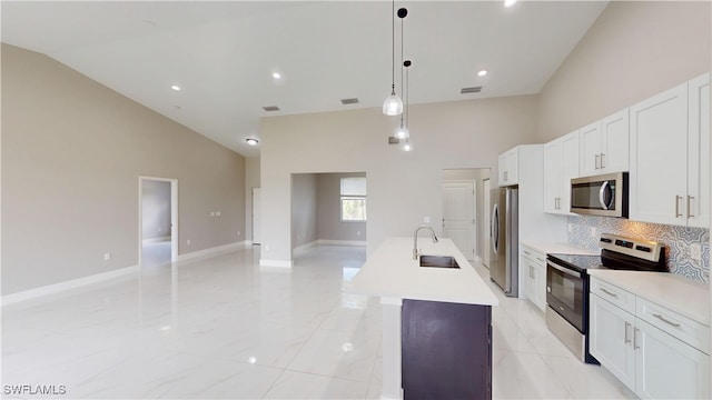 2505 4th St SW, Lehigh Acres, FL 33976 - kitchen featuring appliances with stainless steel finishes, a sink, high vaulted ceiling, an island with sink, and open floor plan