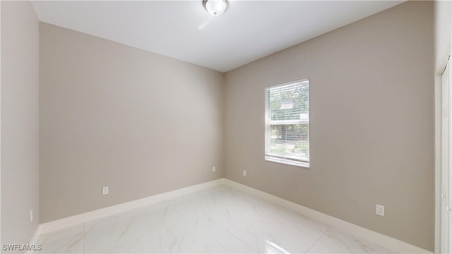 2505 4th St SW, Lehigh Acres, FL 33976 - empty room featuring light marble finish floors and baseboards