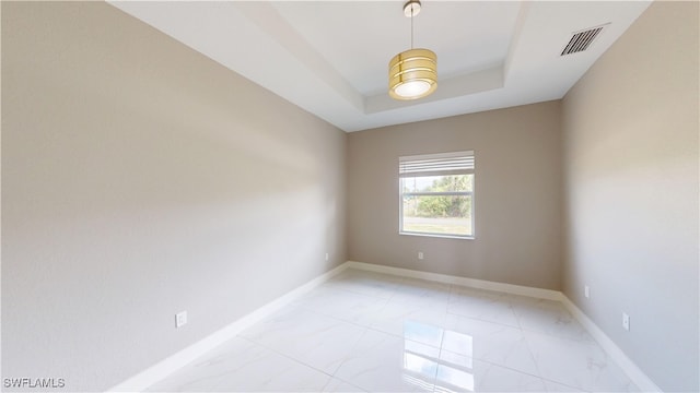 2505 4th St SW, Lehigh Acres, FL 33976 - unfurnished room with light marble finish floors, baseboards, and a tray ceiling