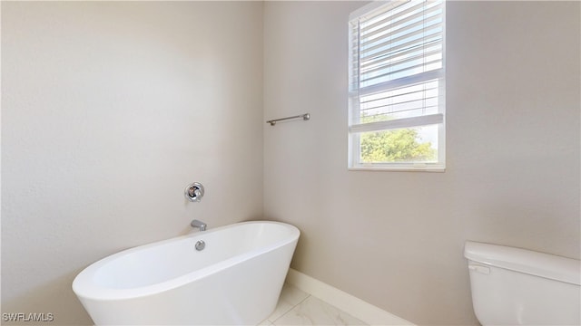 2505 4th St SW, Lehigh Acres, FL 33976 - full bathroom featuring a freestanding bath, toilet, baseboards, and marble finish flooring