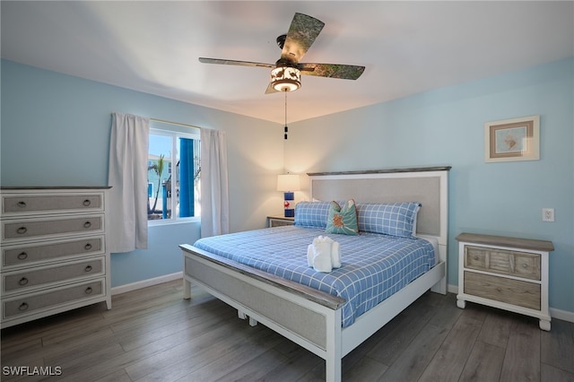 bedroom featuring wood finished floors, baseboards, and ceiling fan
