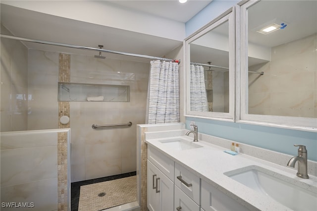 full bathroom with tiled shower and double vanity