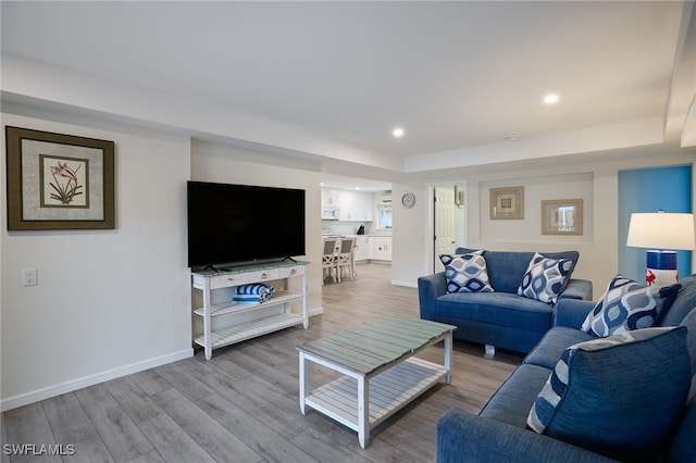 living room featuring light wood-style floors, baseboards, and recessed lighting