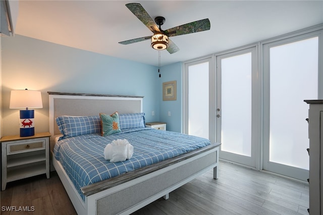 bedroom with wood finished floors, access to exterior, and a ceiling fan