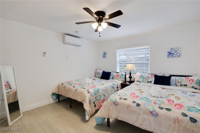 bedroom with a wall unit AC, light wood-style flooring, baseboards, and ceiling fan