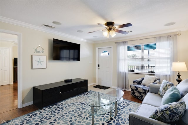 living area with crown molding, wood finished floors, a ceiling fan, and baseboards