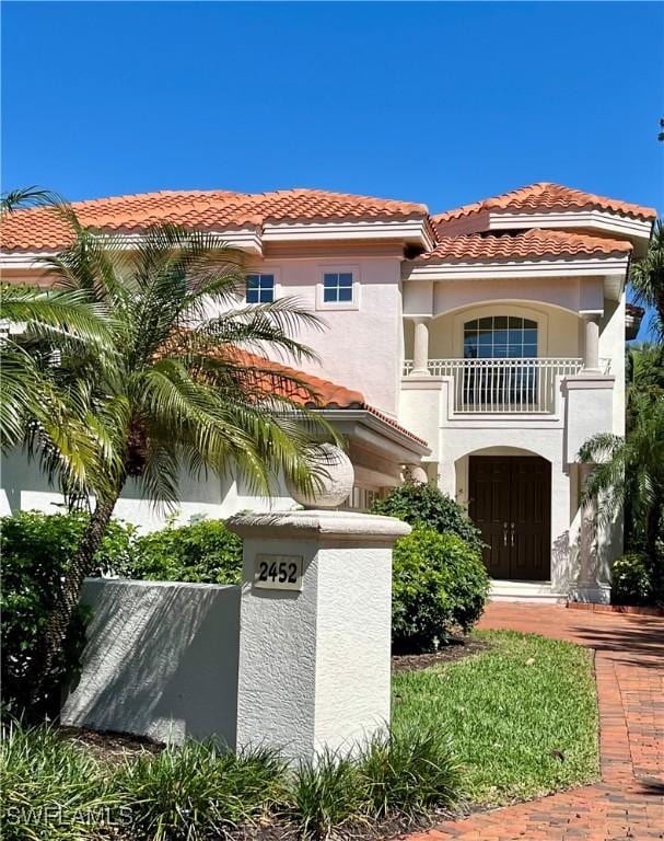 2452 Terra Verde Ln Unit 2452, Naples, FL 34105 - view of front of home featuring a balcony, stucco siding, a tiled roof, and fence