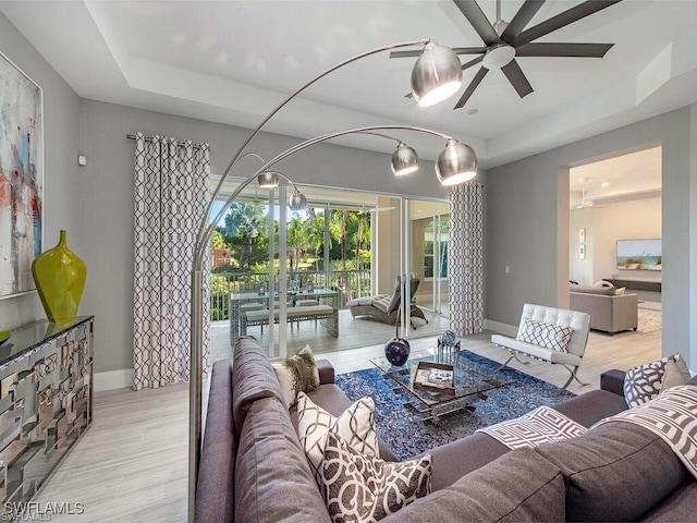 2452 Terra Verde Ln Unit 2452, Naples, FL 34105 - living area featuring a raised ceiling, a ceiling fan, baseboards, and light wood-style floors