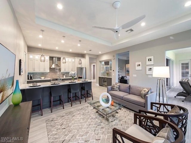 2452 Terra Verde Ln Unit 2452, Naples, FL 34105 - living area with a tray ceiling, light wood-type flooring, ceiling fan, and recessed lighting