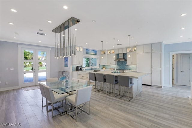 dining space with baseboards, recessed lighting, french doors, light wood finished floors, and ornamental molding