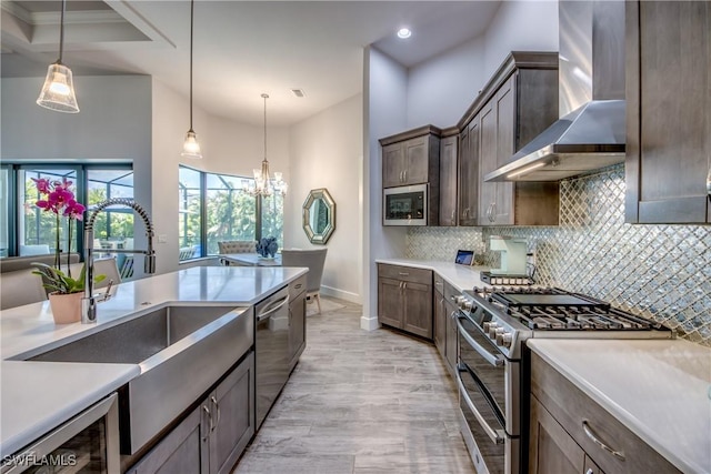 3726 Ceitus Pkwy, Cape Coral, FL 33991 - kitchen with stainless steel appliances, wall chimney range hood, a sink, a chandelier, and baseboards
