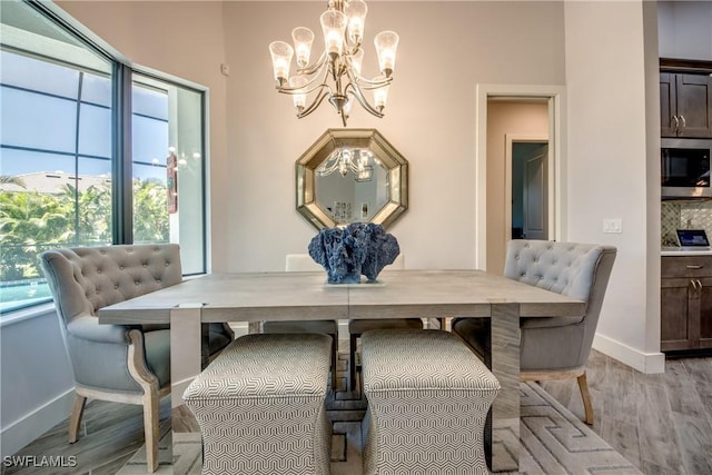 3726 Ceitus Pkwy, Cape Coral, FL 33991 - dining space featuring a chandelier, healthy amount of natural light, baseboards, and light wood-style floors