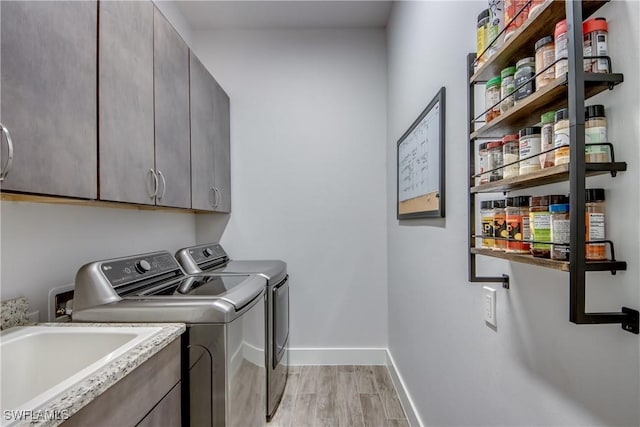3726 Ceitus Pkwy, Cape Coral, FL 33991 - laundry room with cabinet space, washing machine and clothes dryer, baseboards, and light wood finished floors