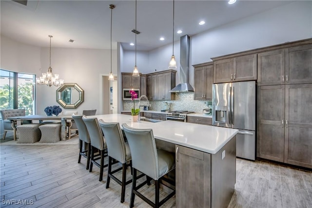 3726 Ceitus Pkwy, Cape Coral, FL 33991 - kitchen with appliances with stainless steel finishes, wall chimney range hood, light wood-style floors, a breakfast bar area, and recessed lighting