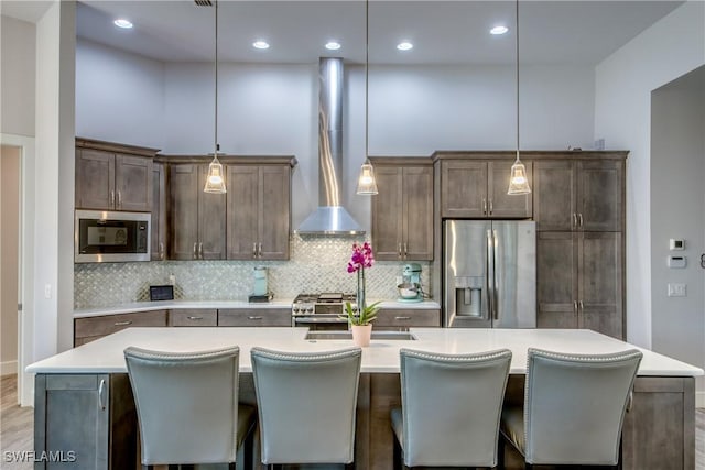 3726 Ceitus Pkwy, Cape Coral, FL 33991 - kitchen featuring stainless steel appliances, wall chimney range hood, an island with sink, light countertops, and backsplash